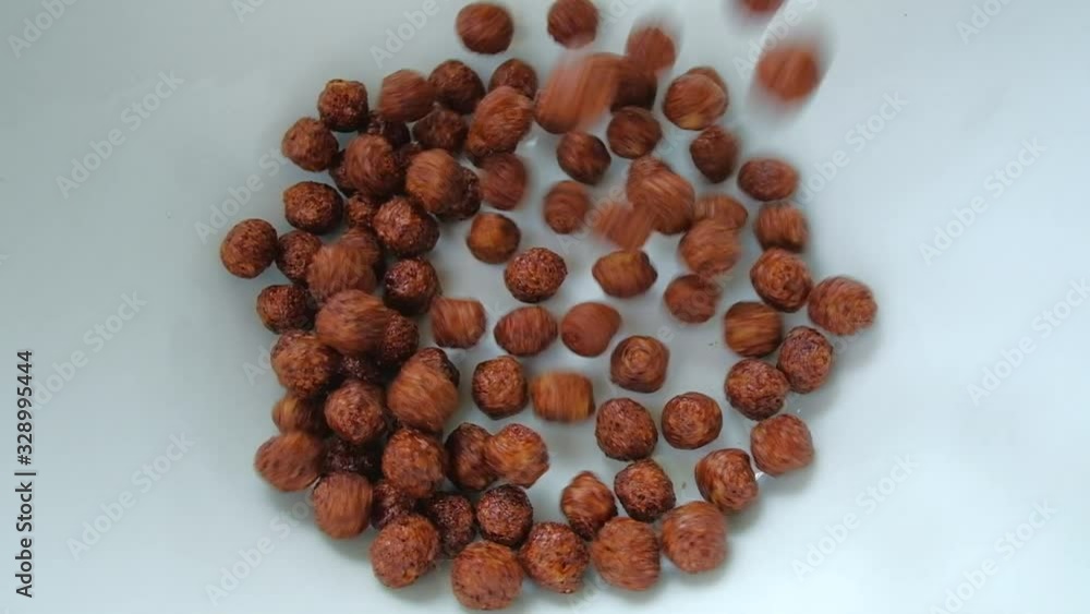 Close up - Chocolate Corn Balls Are Falling Into The Plate. Slow Motion. The concept of morning Breakfast. Close up - Chocolate Corn Balls Are Falling Into The Plate. Slow Motion. The concept of morning Breakfast.