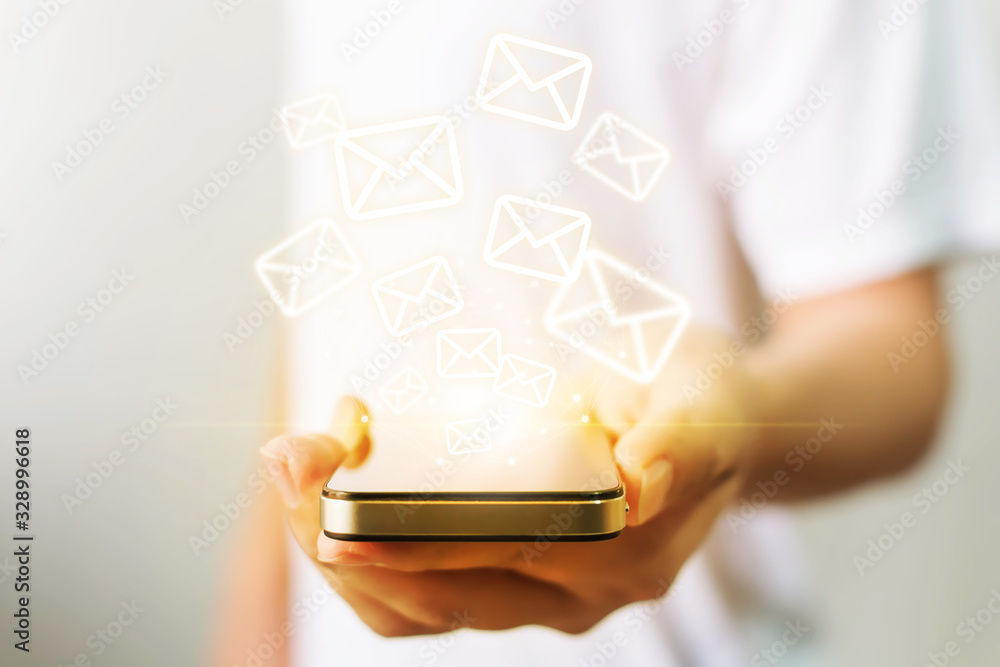Close-up image of male hands holding smartphone with icon envelope email. Contact us customer service or e-mail marketing concept Close-up image of male hands holding smartphone with icon envelope email. Contact us customer service or e-mail marketing concept