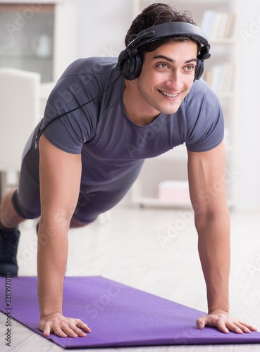 Man doing sports at home and listening to music