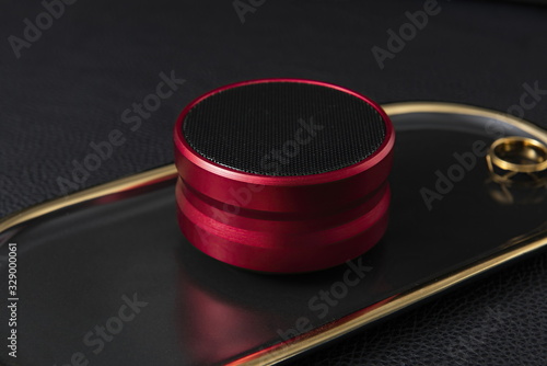 Modern Bluetooth speaker, mini Bluetooth speaker. Blue red black wireless portable Bluetooth speaker, leather background isolation photo