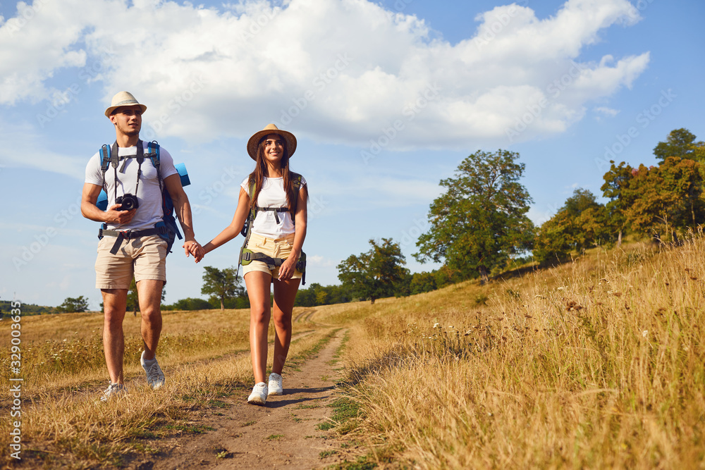 Couple travelers with backpack on hike in nature Couple travelers with backpack on hike in nature