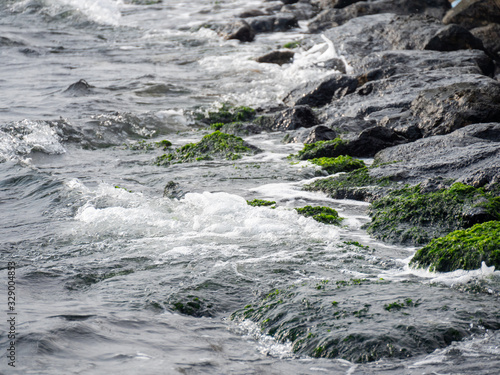 Waves hit the rocks and splashing sea water.