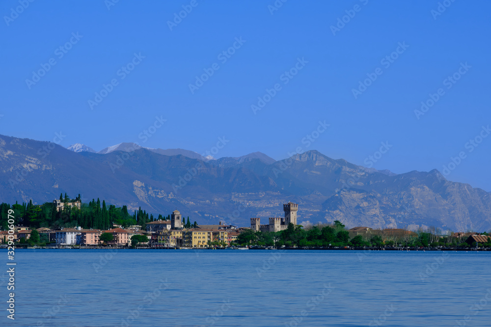Sirmione island Lake Garda, Italy. In the background mountains and blue sky