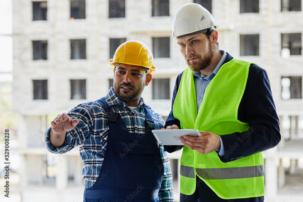 Two engineers discuss work related questions together. Two engineers discuss work related questions together.
