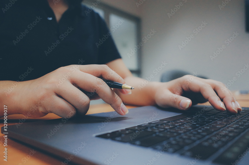 Fototapeta premium freelancer working on laptop computer and holding pen