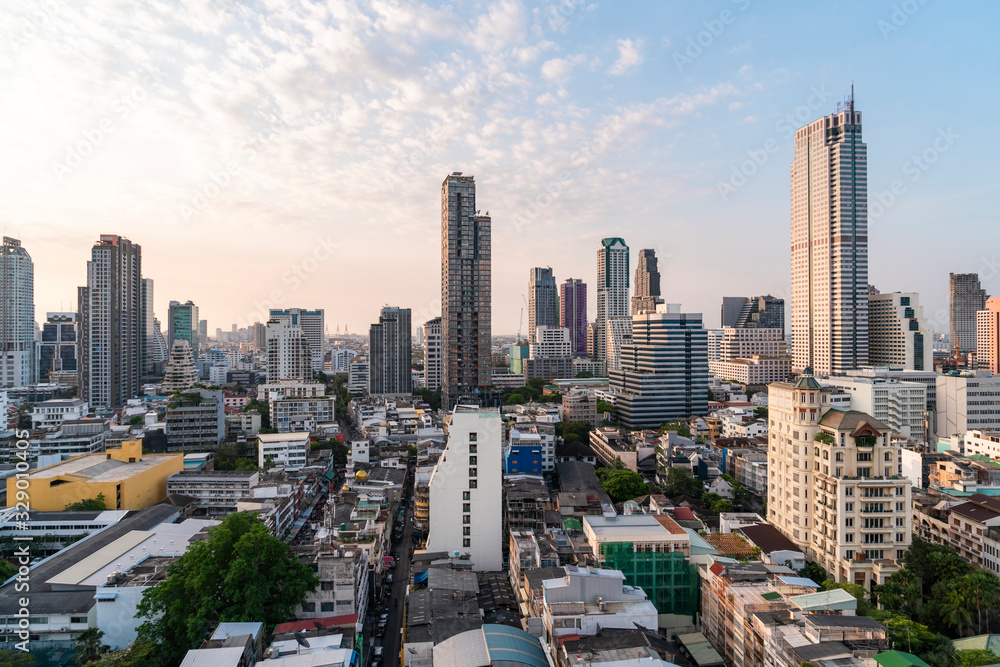 Fototapeta premium Aerial cityscape of picturesque Bangkok at sunset from rooftop view. Panoramic sunrise skyline of the biggest city in Thailand. The concept of metropolis.