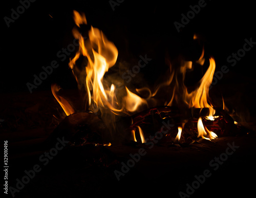 Fire flame caused by burning of wood on a black background