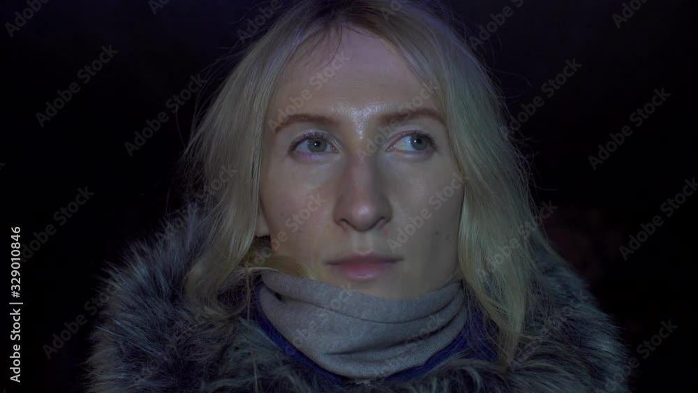 Portrait of shocked scared young woman. She is lit by police flashing lights and is talking on phone. woman is scared, desperately wants something, covering her mouth with hands of problem. Portrait of shocked scared young woman. She is lit by police flashing lights and is talking on phone. woman is scared, desperately wants something, covering her mouth with hands of problem.