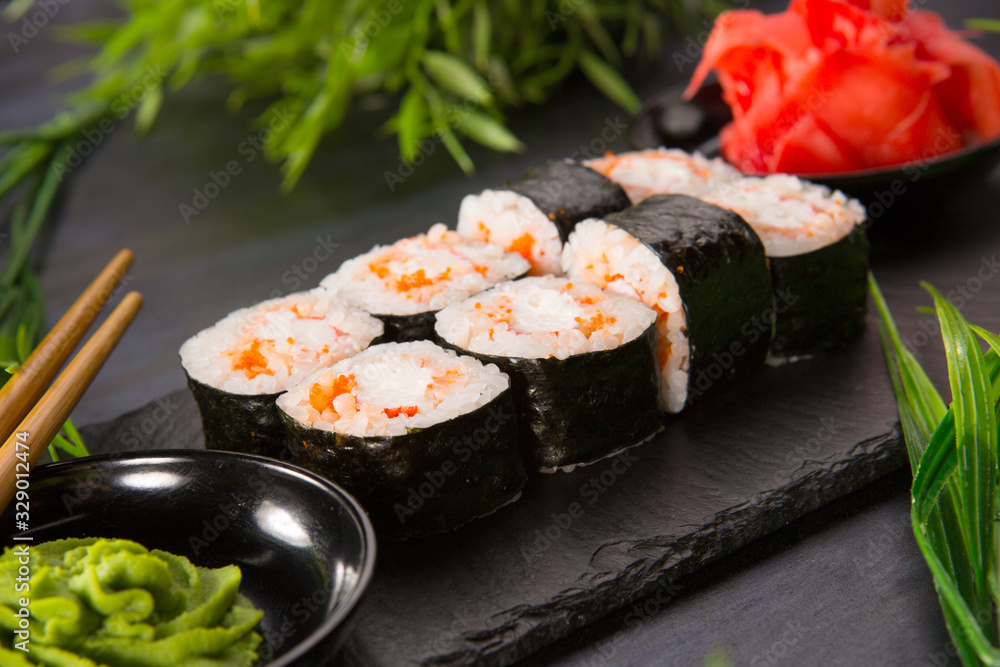 Set of sushi rolls with wasabi and ginger on a black background. Japanese oriental cuisine Set of sushi rolls with wasabi and ginger on a black background. Japanese oriental cuisine