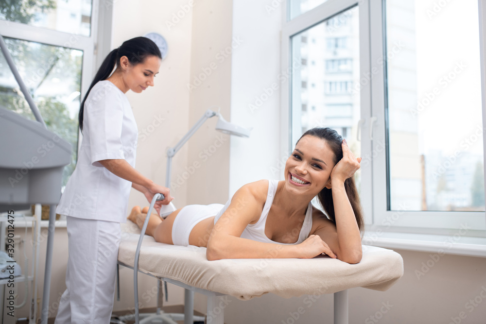 Woman smiling broadly feeling good in massage clinic Woman smiling broadly feeling good in massage clinic