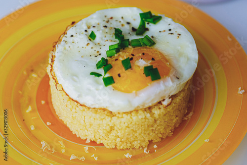 Fried egg with couscous Light background photo