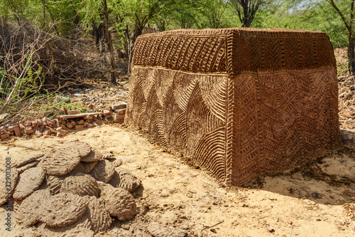 Small hut that are built to store cow or buffalo dung that will be used later as traditional cooking fuel on hearths. Nandgaon. India photo