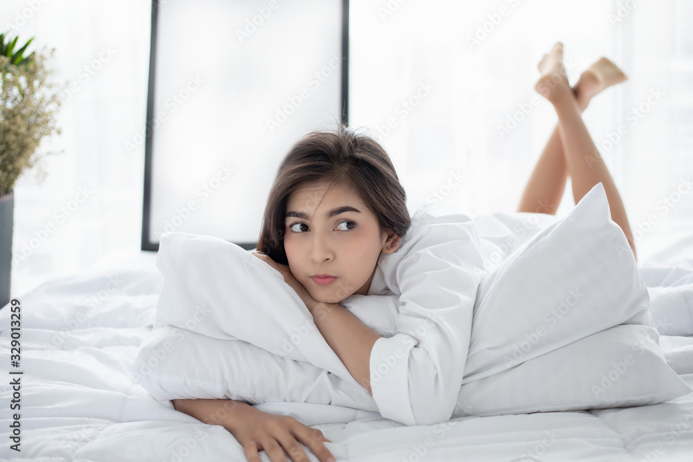 Asian woman Beautiful young smiling woman sitting and sleeping in white bed and stretching in the morning at bedroom after waking up in her bed fully rested Asian woman Beautiful young smiling woman sitting and sleeping in white bed and stretching in the morning at bedroom after waking up in her bed fully rested