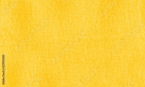 Vibrant yellow texture of binding fabric. Yellow textile background with natural folds. Close-up