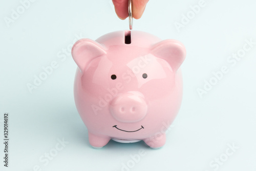 Piggy Bank on white background, space for text. A woman's hand whith coin. Finance, saving money