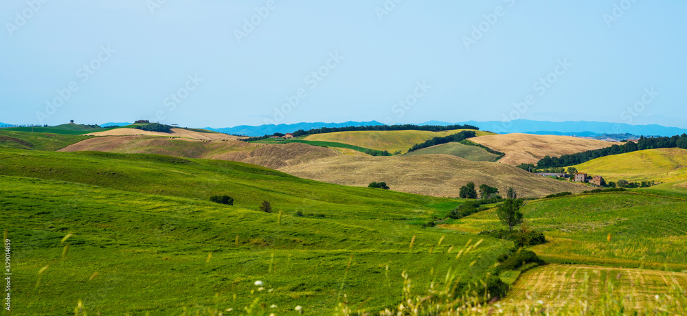 Beautiful view in Tuscany, Italy. Rural landscape. Countryside hills and meadows, green and yellow fields and sky. Beautiful world.
