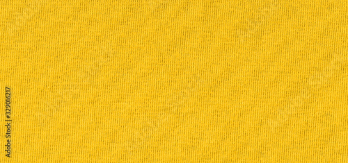 Vibrant yellow texture of binding fabric. Yellow textile background with natural folds. Close-up