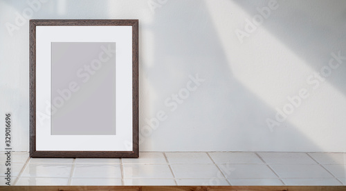 Wooden picture frame with blank page on ceramec top table.