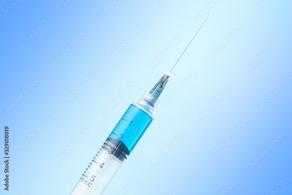 syringe with vaccine on blue background syringe with vaccine on blue background