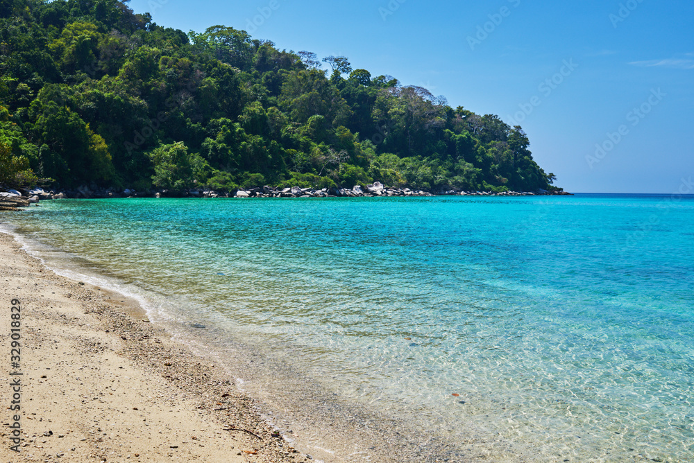 Tropical scenery view. Beach of Tioman island in Malaysia with perfect white sand, palm trees, turquoise water and deep blue sky. Idyllic landscape. Summer vacation and tropical beach concept.