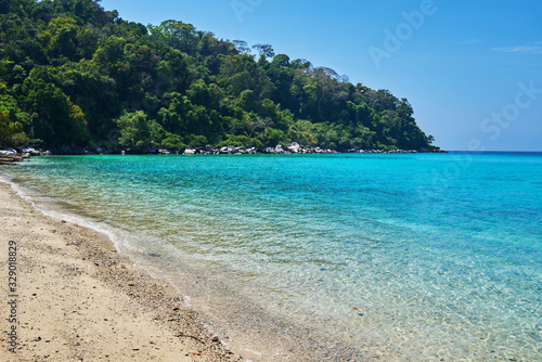 Tropical scenery view. Beach of Tioman island in Malaysia with perfect white sand  palm trees  turquoise water and deep blue sky. Idyllic landscape. Summer vacation and tropical beach concept.