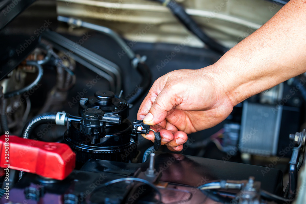 Close up hand a man remove plug for replace the oil filter at modern diesel engine. car maintenance concept in engine room.. Close up hand a man remove plug for replace the oil filter at modern diesel engine. car maintenance concept in engine room..