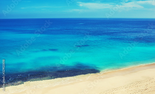 White sand beach and turquoise sea background. Coastline on sunny day background of sea and sky, white sand, tourism, relax, vacation, summer, ocean. Bali Island.