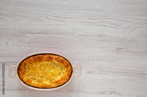 Homemade Cheese Corn Pudding Casserole on a white wooden table, top view. Flat lay, overhead, from above. Copy space.