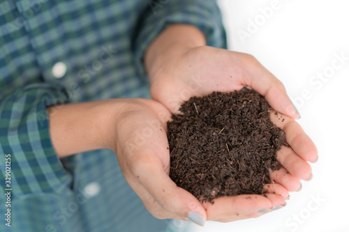 Close up hand of asian woman holding fertilizer compost in her hand on white background, Selective focus, Agricultural and ecology growing concept.