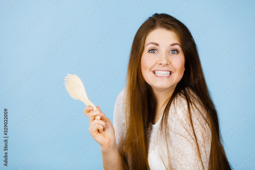 Happy woman holding brush about to brushing her hair Happy woman holding brush about to brushing her hair