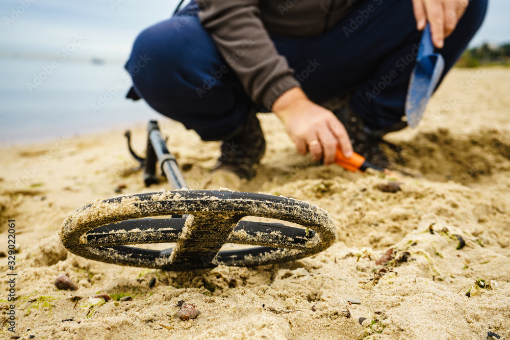 Naklejka premium Man with metal detector on sea beach