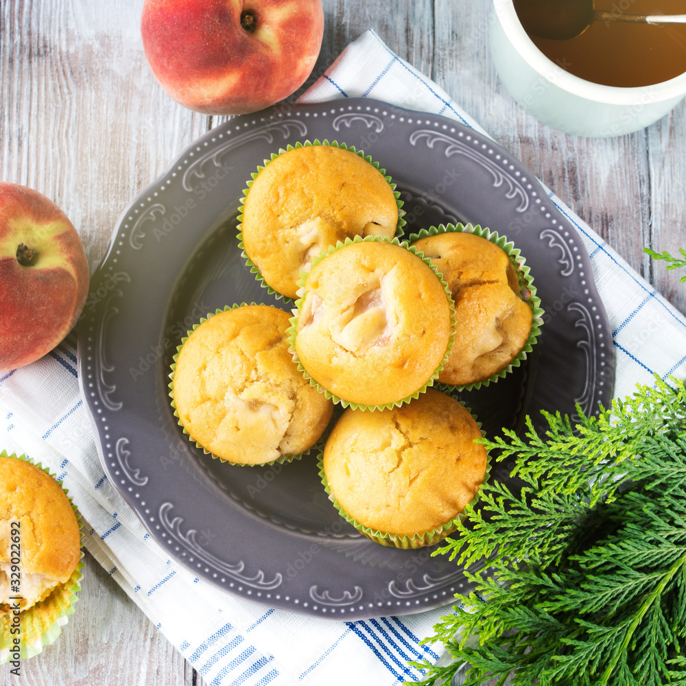 Vegan eggs free spelt wheat muffins with peaches and apples in green paper cases on checkered napkin Vegan eggs free spelt wheat muffins with peaches and apples in green paper cases on checkered napkin