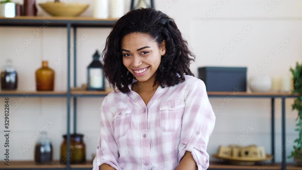 African American girl smiling bashfully at camera at home African American girl smiling bashfully at camera at home