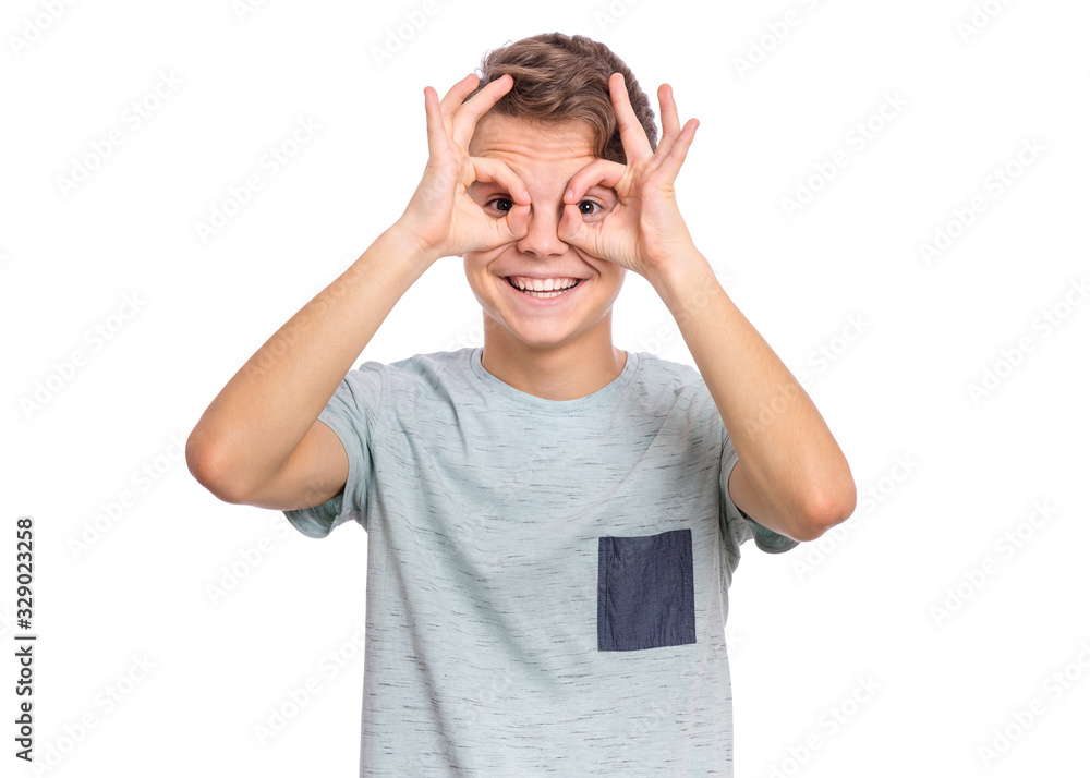 Portrait of handsome teen boy making Ok Gesture with hand on eyes looking through fingers. Beautiful caucasian teenager, isolated on white background. Happy smiling child showing glasses okay. Portrait of handsome teen boy making Ok Gesture with hand on eyes looking through fingers. Beautiful caucasian teenager, isolated on white background. Happy smiling child showing glasses okay.