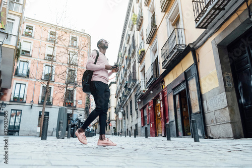 Handsome smart african man typing mobile phone at the street. Communication concept