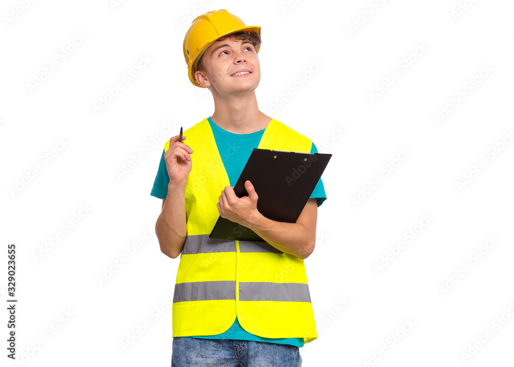 Handsome Teen Boy wearing Safety Jacket and yellow Hard Hat with Clipboard on hands. Portrait of Child - young technician with clipboard in hands taking necessary notes, isolated on white background. Handsome Teen Boy wearing Safety Jacket and yellow Hard Hat with Clipboard on hands. Portrait of Child - young technician with clipboard in hands taking necessary notes, isolated on white background.