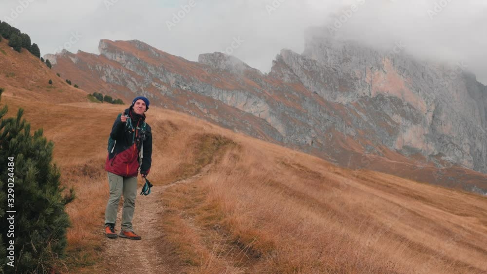 Adventurous man traveler hiking in the misty mountain peaks of the Dolomites in Italy. Adventurous man traveler hiking in the misty mountain peaks of the Dolomites in Italy.
