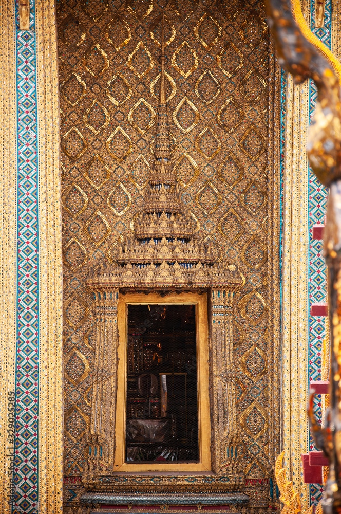 Golden carved wood Thai window of Bangkok Grand Palace building - Emerald Buddha temple