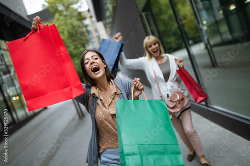 Shopping and tourism concept. Beautiful women friends with shopping bags in ctiy