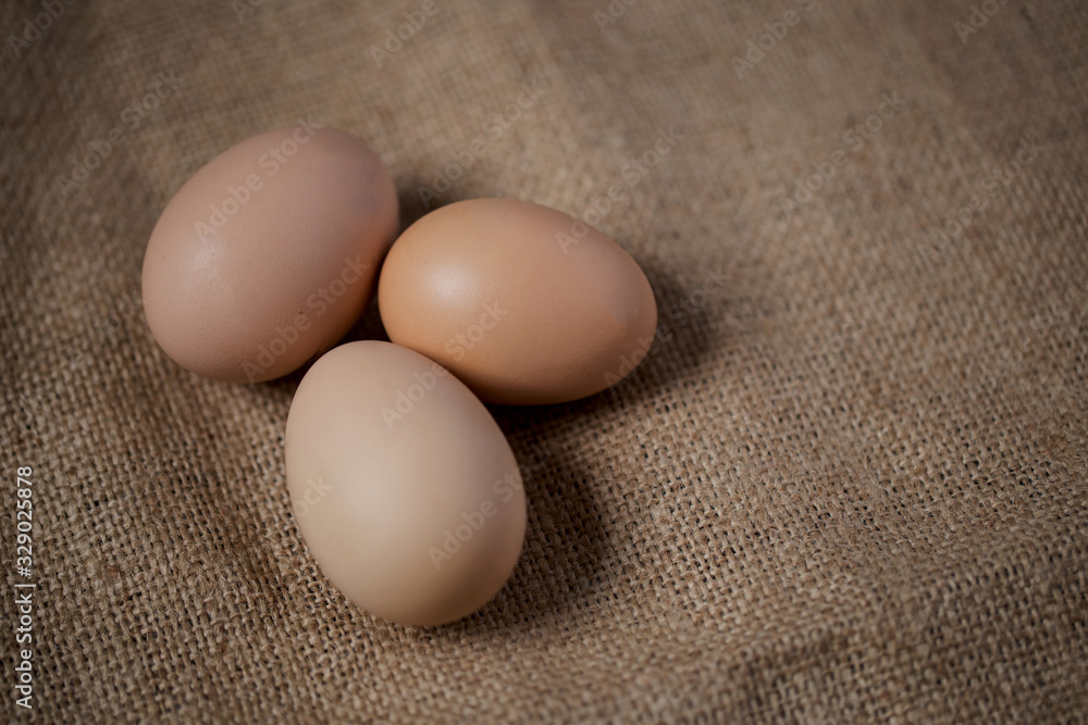 Beautiful brown yellow eggs on the brown cloth Beautiful brown yellow eggs on the brown cloth