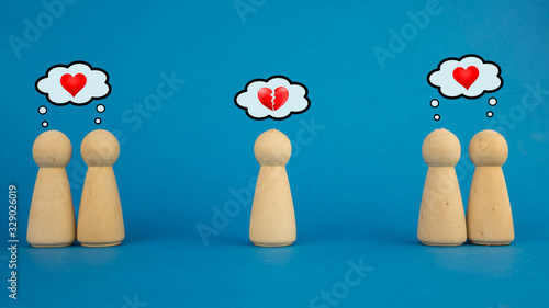 two couples in love and one man with a broken heart on a blue background. the concept of unrequited love