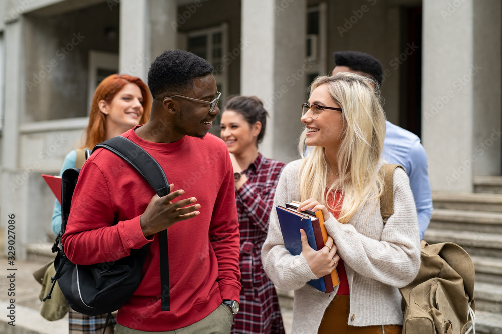 Obraz premium Multiethnic student friends walking in college campus