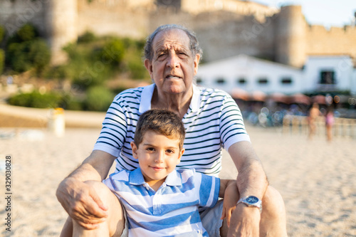 Portrait of grangfather and grandson on the beach photo