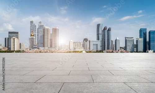 Empty square floor tiles and Qingdao urban architecture skyline..