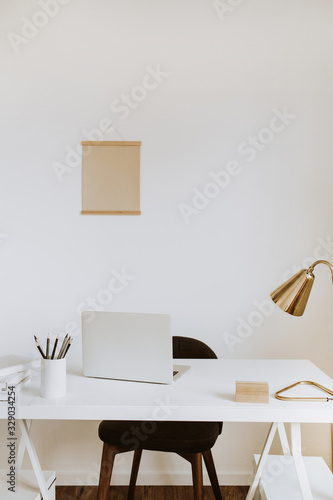 Modern minimal interior design concept. Bright Scandinavian home office desk table workspace with laptop, lamp, books. Business study cabinet. Girl boss studio concept. © Floral Deco
