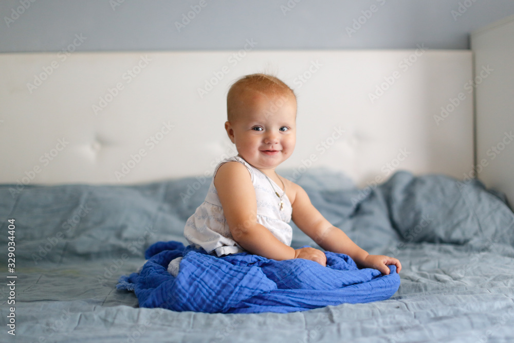 Caucasian toddler kid smiling on bed in bedroom