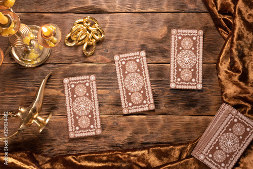 Tarot cards on brown wooden table flat lay background.