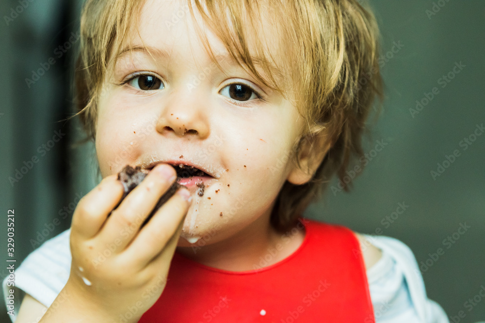 portrait adorable child eating chocolate sponge cake portrait adorable child eating chocolate sponge cake
