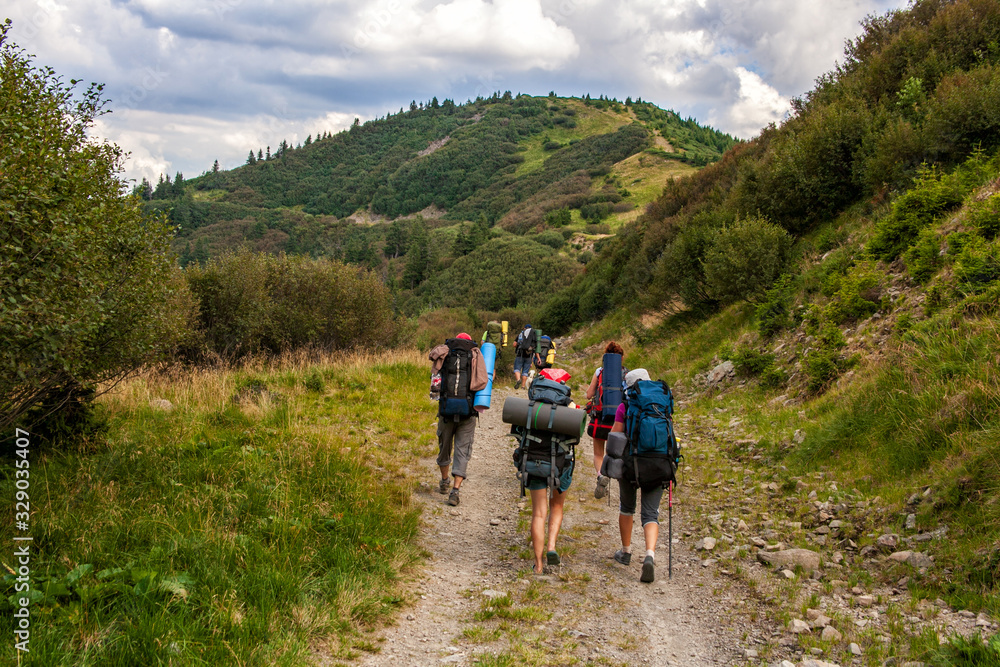 A group of tourists on a mountain trail. The concept of travel, adventure or expedition in the mountains.