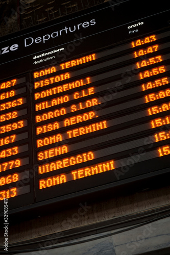 Close-up of Italian departures board for destinations in Italy including Rome, Milan, Venice, and Siena at a train station in Florence, Italy